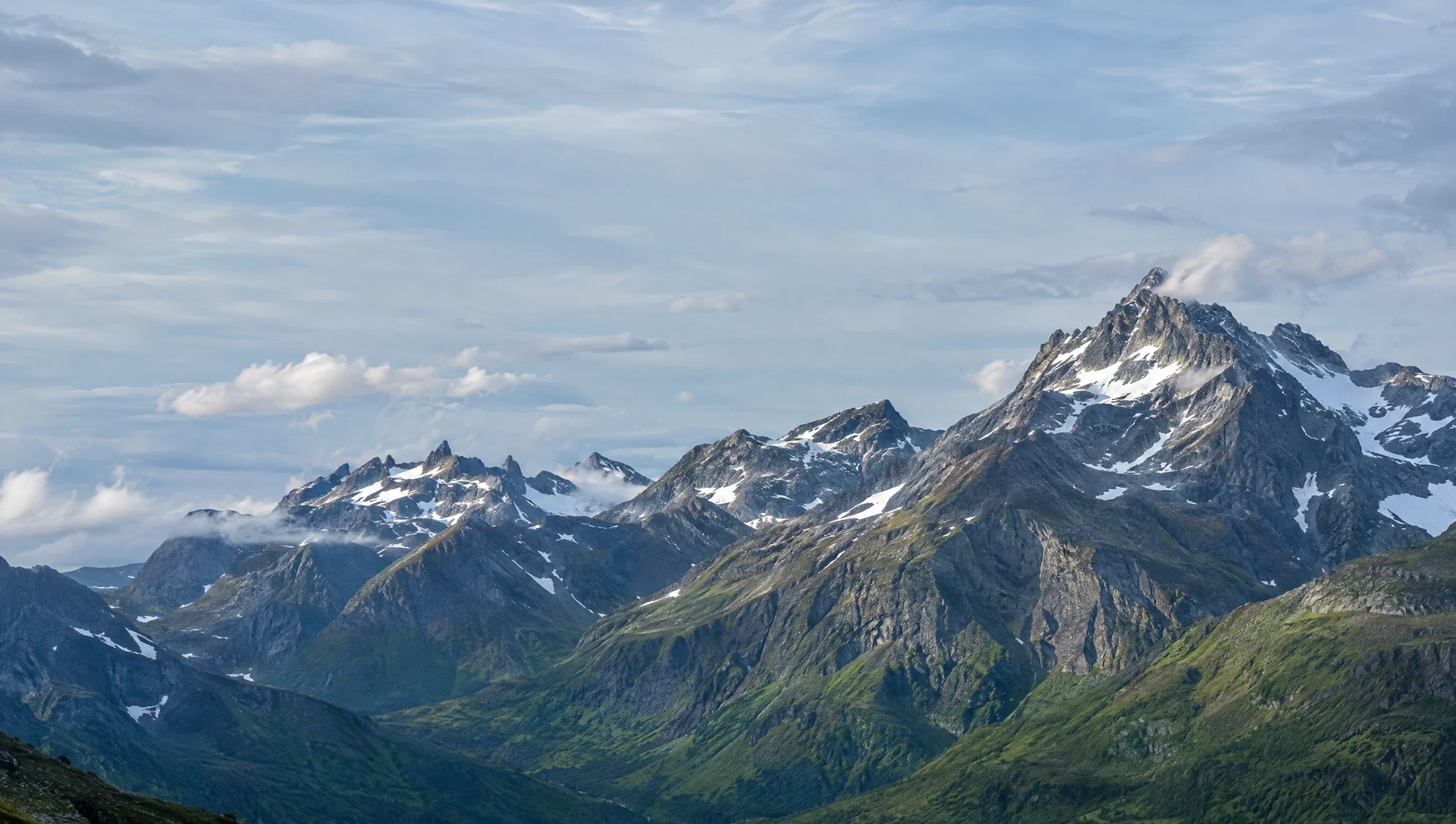 Dramatisk norsk fjellrygg som stiger mot en lys himmel